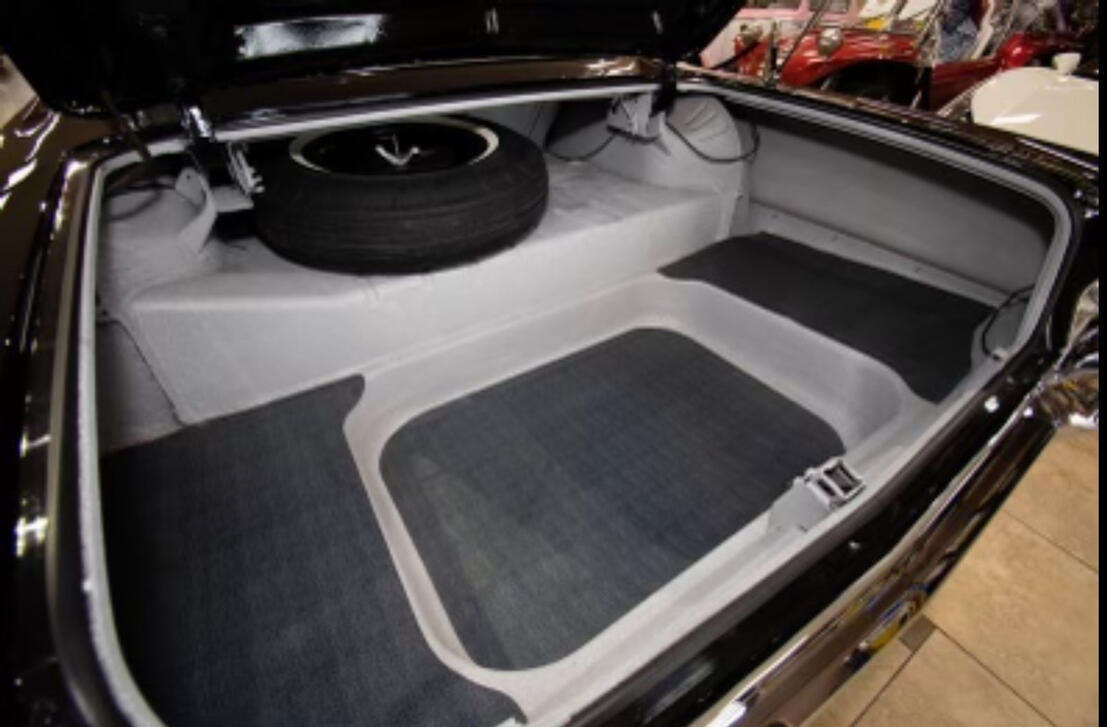 Trunk reupholstery: light gray custom panels with matching mats and spare tire neatly integrated.